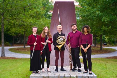 The Southern Wind Quintet standing in a semi-circle in front of a sculpture