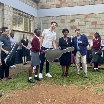 Braden Rymer (center) presenting a guitar to one of the Moi Girls School students while the Headmaster (right of Rymer) and Pete Jutras (far right) conduct the gift ceremony.