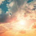 Colorful sky with the sun shining through the clouds at sunset